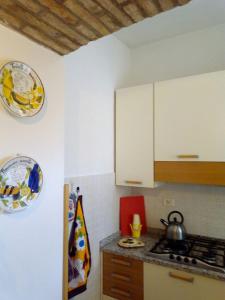 a kitchen with white cabinets and a stove top oven at Casa Michelangelo in Megognano