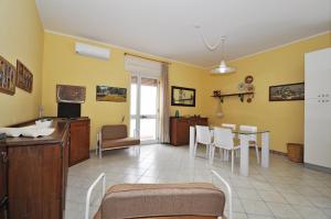 - un salon avec une table et des chaises dans l'établissement Dea Minerva Apartment by Salento Affitti, à Torre San Giovanni