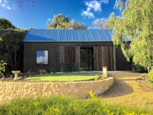 a small house with a blue roof at The Garden Cottage at The Olives in Yankalilla