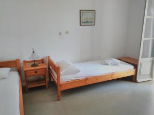 ナウサにあるIoli Apartmentsのベッドルーム(木製ベッド1台、ナイトスタンド付)
