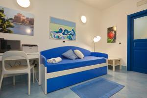 a room with a blue bed and a desk with a computer at Appartamenti Rosa Dei Venti in Trapani