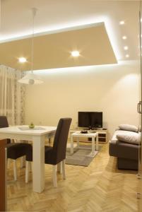 a living room with a white table and a tv at Square Studio Apartment in Niš