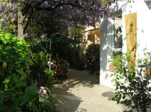 a patio with a table and an umbrella in a garden at b&b undici in Cervia