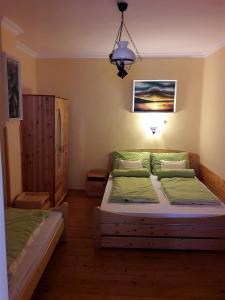 1 dormitorio con 2 camas y lámpara de araña en Viktor Vendégház, en Tokaj
