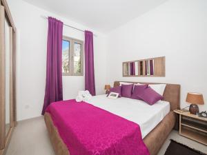a bedroom with a large bed with purple curtains at Apartments Castello in Kotor
