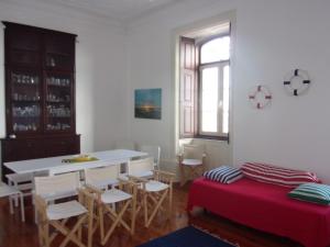 a living room with a table and chairs and a kitchen at Hostel 402 in Figueira da Foz