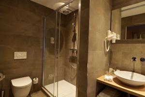 a bathroom with a toilet, sink and shower at Hotel De Zoete Inval Haarlemmerliede in Haarlem