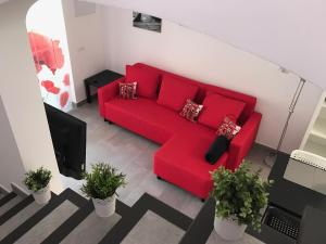 Vista Faro 39 في ماسبالوماس: أريكة حمراء في غرفة المعيشة بالنباتات