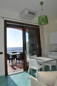 kuchnia ze stołem i krzesłami oraz balkon w obiekcie Residence Tre Palme w mieście Acciaroli