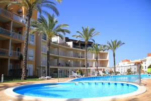 a swimming pool in front of a hotel with palm trees at MSHomes Corcovada in Albufeira