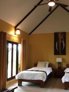a bedroom with two beds and a window at Baan Thai House in Phra Nakhon Si Ayutthaya