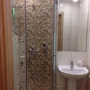 a bathroom with a shower and a sink at Apartament na Vielikoy in Velikiy Novgorod