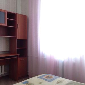 ヴェリーキー・ノヴゴロドにあるApartament na Vielikoyのベッドルーム1室(ベッド1台付)、窓(カーテン付)