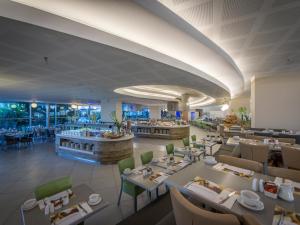 a rendering of a restaurant with tables and chairs at Neptune Eilat By Dan Hotels in Eilat