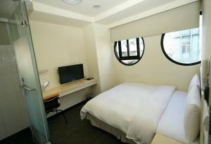 a hotel room with a bed and a television at Century Hotel in Kaohsiung