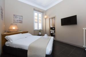 a bedroom with a bed and a flat screen tv at App Condotti Luxury Apartment In Rome in Rome