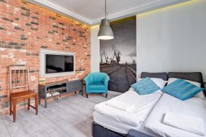 a living room with a bed and a brick wall at Apartment Mariacka Exclusive in Gdańsk