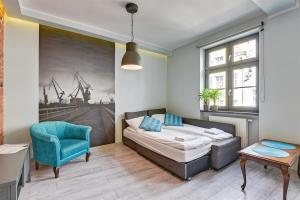sypialnia z łóżkiem i niebieskim krzesłem w obiekcie Apartment Mariacka Exclusive w Gdańsku