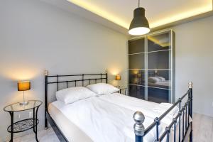 a bedroom with a large white bed and a table at Apartment Mariacka Exclusive in Gdańsk