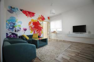 a living room with a blue couch and a tv at The Green Apartments in Magarevo