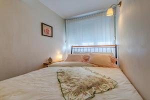 een bed met roze kussens en een raam in een kamer bij Apartments Zoran in Split