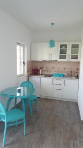 cocina con mesa azul y 2 sillas en Apartments La Dolce Vita en Herceg-Novi