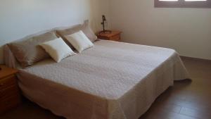a bedroom with a large bed with two pillows at Affittacamere Dolci Notti in Budoni +14 photos