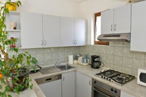 a kitchen with white cabinets and a sink at Apartment Juras in Opatija +15 photos