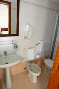 パトゥにあるMasseria San Nicolaのバスルーム(洗面台、トイレ、鏡付)