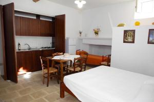 パトゥにあるMasseria San Nicolaのキッチン、テーブル、ベッドが備わる客室です。