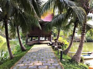 a path with palm trees in front of a building at Baan Thai House in Phra Nakhon Si Ayutthaya