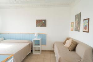 アグリジェントにあるLa Terrazza di Agrigentoのベッドルーム1室(ベッド2台、ソファ付)