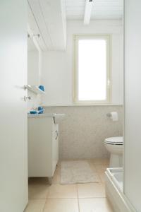 アグリジェントにあるLa Terrazza di Agrigentoの白いバスルーム(トイレ、窓付)