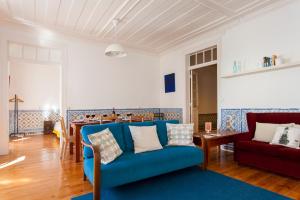 uma sala de estar com um sofá azul e uma mesa em ALTIDO Classic 3BR home with workspace in Chiado, 2mins from Baixa-Chiado subway em Lisboa