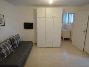 a living room with a couch and a cabinet at Schreng Apartments in Malinska