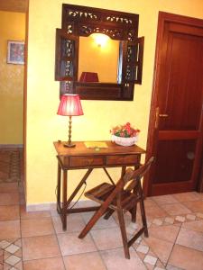 a table with a lamp and a chair and a mirror at Max House in Rome