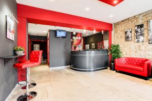 a living room filled with furniture and a red wall at Best Western Nouvel Orléans Montparnasse in Paris