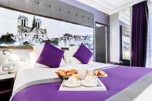 Una habitación de hotel con una cama con una bandeja de comida. en Best Western Nouvel Orléans Montparnasse en París