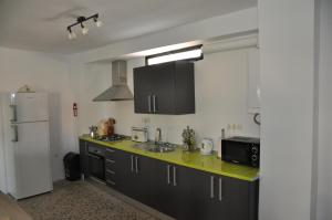 a kitchen with black cabinets and a white refrigerator at Casa Tamayo in Órgiva