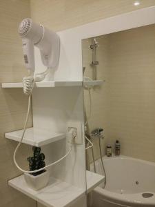 a white bathroom with a blow dryer and a sink at Lux Life Apartment in Belgrade +18 photos