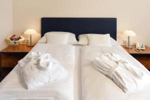 a hotel room with two beds and two night stands at Hotel Arkadia in Friedrichsdorf