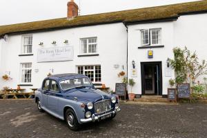 un viejo coche azul estacionado frente a un edificio en Rams Head Inn en Dolton