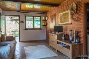 a living room with a tv and a brick wall at Domek letniskowy Sieraków in Sieraków