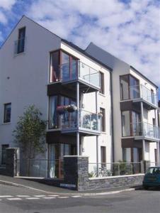 a large white building with a person on a balcony at Apartment 2 The Waterfront in Portaferry
