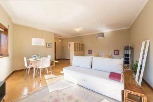 a living room with a white couch and a table at BmyGuest - Santa Catarina Light Apartment in Porto