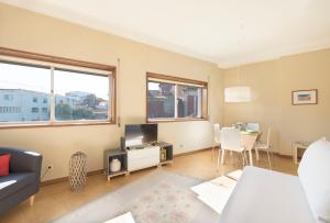 a living room with a couch and a tv at BmyGuest - Santa Catarina Light Apartment in Porto