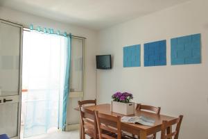 a dining room with a table and chairs and a window at Residence La Poesia - Direzione Salento in Torre dell'Orso