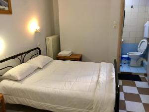 a bedroom with a bed and a bathroom with a toilet at Hotel Kastoria in Thessaloniki