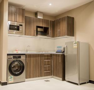 a kitchen with a refrigerator and a dishwasher at ألاجنحة المخملية للشقق المخدومة- النهضة in Jeddah