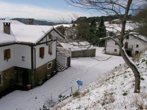 uma casa com neve no telhado em Agroturismo Kasa Barri em Bermeo